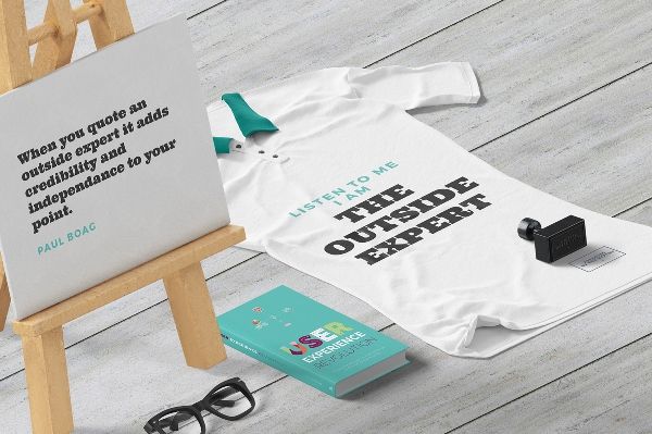 Image of a printed t-shirt, book, glasses and placard with the text